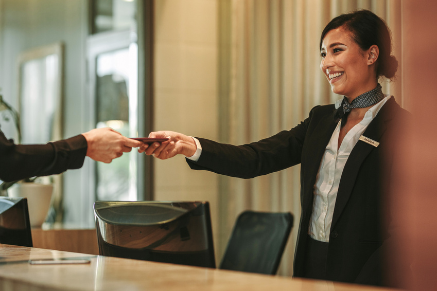 Smiling Receptionist Attending to Hotel Guest